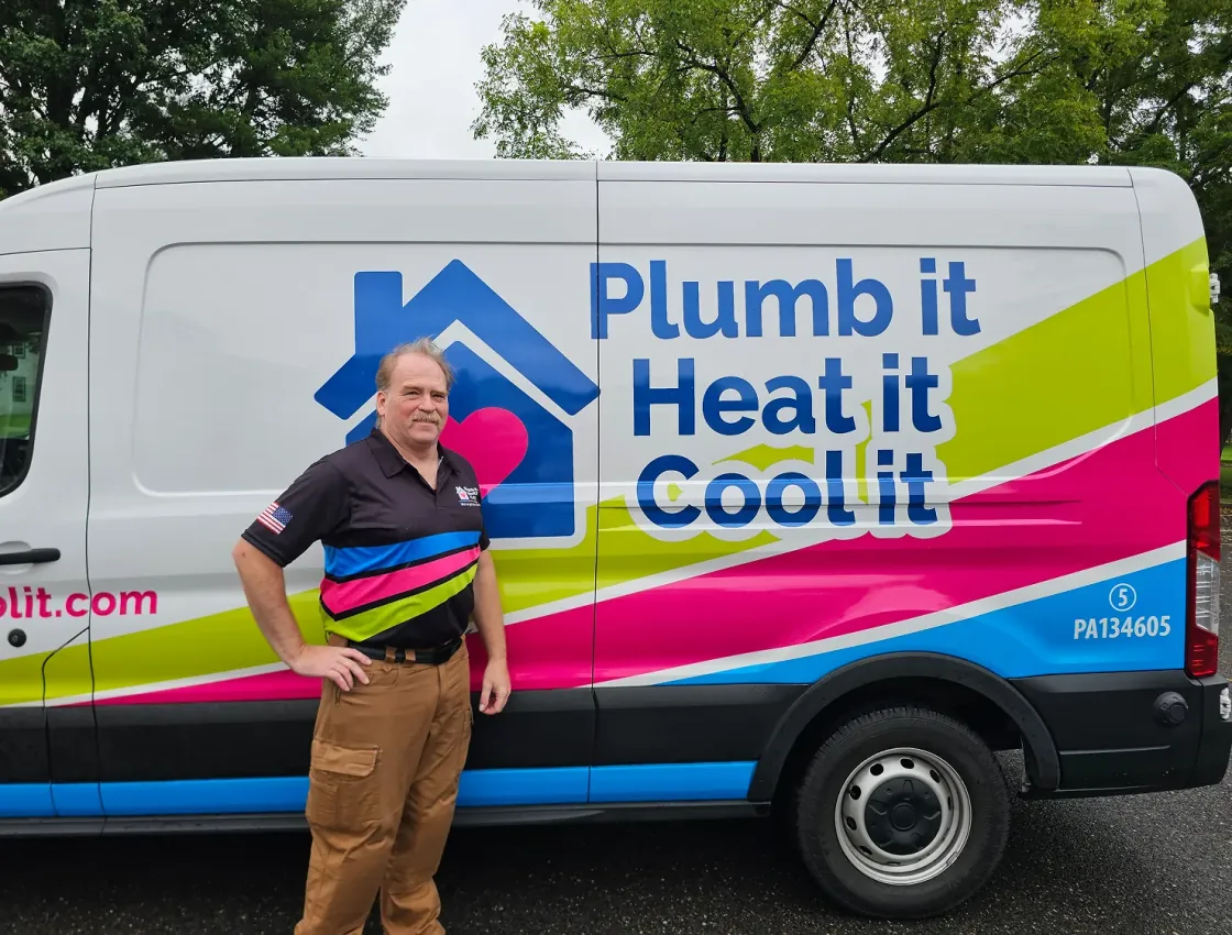Plumb it Heat it Cool it technician in front of service truck
